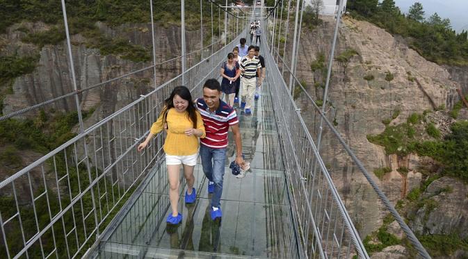 Para turis ketakutan saat mencoba jembatan gantung transparan di China. (Reuters)