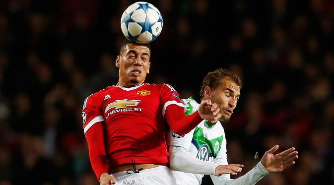 Bek MU, Chris Smalling berebut bola udara dengan penyerang Wolfsburg, Bas Dost pada laga Liga Champions di Stadion Old Trafford, Inggris, Kamis (1/10/2015). MU menang atas Wolfsburg dengan skor 2-1. (Reuters/Lee Smith)