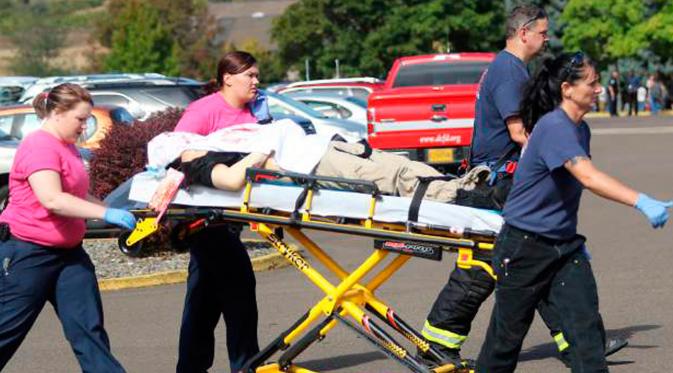 Petugas mengevakuasi korban terluka setelah penembakan yang terjadi di Umpqua Community College di Roseburg, Oregon, AS, Kamis (1/10/2015). 13 orang tewas dan sekitar 20 lainnya terluka akibat kejadian tersebut. (REUTERS/Michael Sullivan/The News-Review)