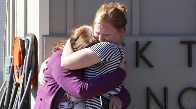Dua orang alumni berpelukan setelah mengetahui penembakan yang terjadi di Umpqua Community College di Roseburg, Oregon, AS, Selasa (1/10/2015). 13 orang tewas dan sekitar 20 lainnya terluka akibat kejadian tersebut. (REUTERS/Steve Dipaola)
