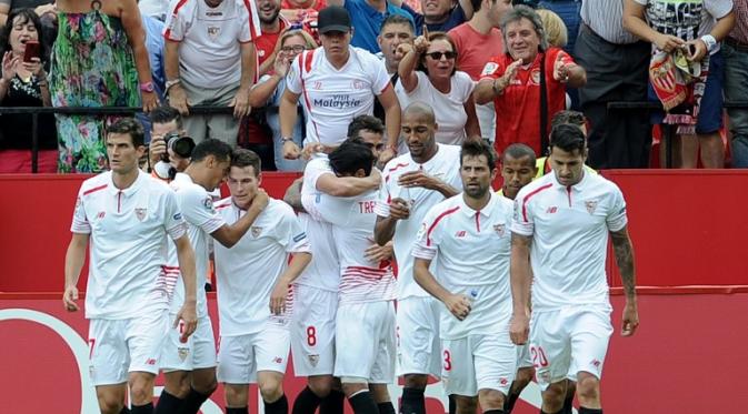 Para pemain Sevilla merayakan gol Vicente Iborra ke gawang Barcelona dalam lanjutan La Liga Spanyol di Estadio Ramon Sanchez Pizjuan, Sabtu (3/10/2015) malam WIB. (Liputan6.com/AFP PHOTO/ CRISTINA QUICLER)