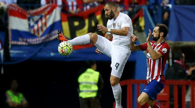 Pemain Real Madrid Karim Benzema (kiri) berebut bola dengan Pemain Atletico Madrid Juanfran Torres dalam lanjutan liga Spanyol di Vicente Calderon stadium in Madrid, Senin (05/10/2015). Atletico vs Madrid seri 1-1.(REUTERS/Sergio Perez)