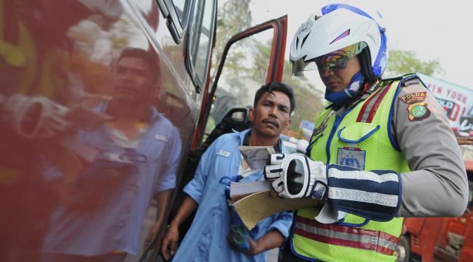 Petugas Dishub dibantu aparat kepolisian melakukan uji emisi kendaraan serta kelengkapan surat pengendara di Terminal Kampung Rambutan, Jakarta (6/10/2015). (Liputan6.com/Gempur M Surya)