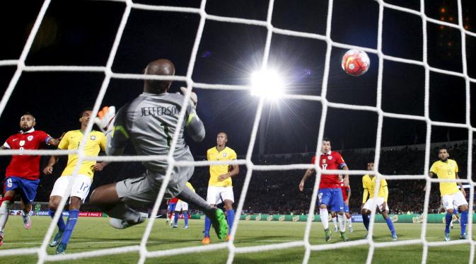 Kiper Brasil Jefferson gagal menghentikan bola sontekan striker Chile Eduardo Vargas dalam kualifikasi Piala Dunia 2018 zona Amerika Selatan, Jumat (9/10/2015). (Liputan6.com/REUTERS/Ivan Alvarado)