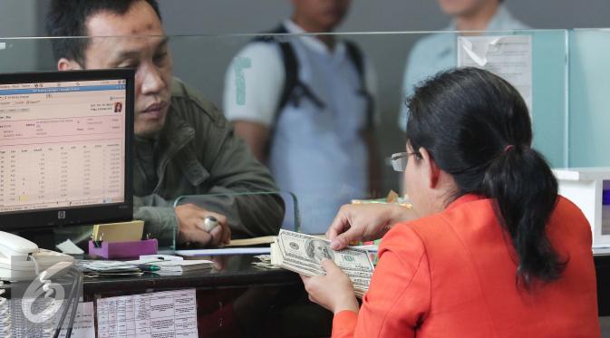 Petugas menghitung uang pecahan US$100 di Jakarta, Jumat (9/10/2015). Nilai tukar rupiah terhadap dolar AS pada perdagangan akhir pekan ini, Jumat (9/10/2015) mengalami penguatan, bahkan bergerak ke level Rp 13.400. (Liputan6.com/Angga Yuniar)