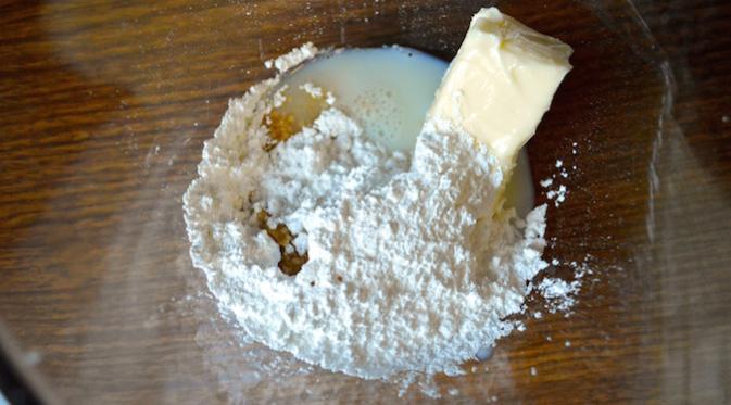 Siapkan wadah besar, tuang 450 gram gula halus, mentega, susu, dan vanilla. Aduk hingga menjadi adonan. (Via: msu.spoonuniversity.com)