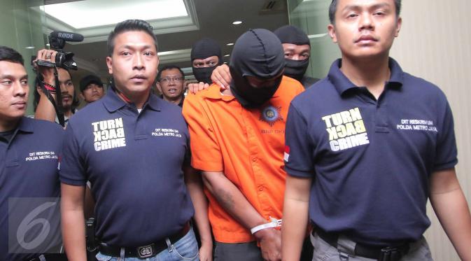 Tersangka pembunuhan bocah yang ditemukan tewas didalam kardus di Kalideres, Agus alias A, dibawa petugas untuk dihadirkan di hadapan media dalam jumpa pers di Polda Metro Jaya, Jakarta, Sabtu (10/10/2015). (/Angga Yuniar)