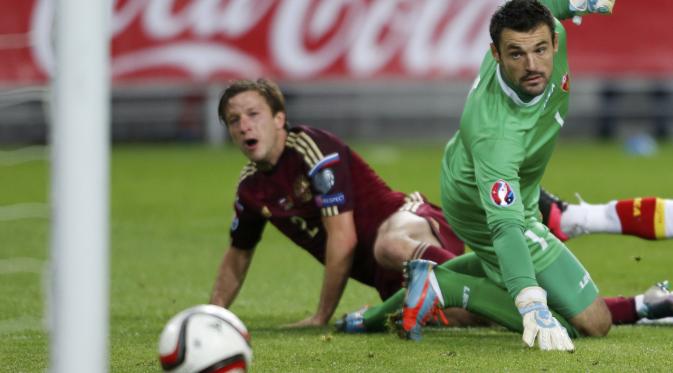 Pemain Rusia Oleg Kuzmin menjebol gawang Montenegro yang dikawal Milan Mijatovic dalam kualifikasi Piala Eropa 2016 Grup G, Senin (12/10/2015). (Liputan6.com/REUTERS/Maxim Zmeyev)