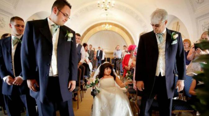 sang ayah, Geoff, merasa bangga berjalan bersama putri tercintanya yang berada di kursi rodanya, menyusuri lorong di hari pernikahannya.