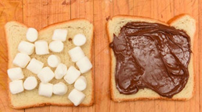 Ambil dua lembar roti. Satu bagian olesi Nutella secara merata, bagian satu lagi taburi dengan marshmallow sampai penuh. (Via: buzzfeed.com)
