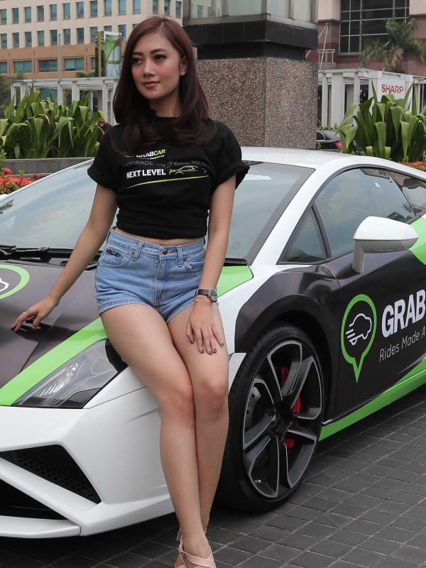 Seorang model berpose di depan supercar mewah milik GrabCar, Jakarta, Rabu (21/10/2015). Supercar ini dapat digunakan secara gratis pada 24-25 Oktober 2015 dan 31 Oktober–1 November 2015. (Liputan6.com/Angga Yuniar)