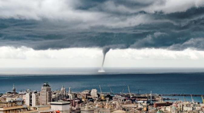 Seorang wisatawan yang sedang berlibur menyaksikan tornado dari kejauhan. Penampilannya indah sekaligus mengerikan. (sumber Caters)