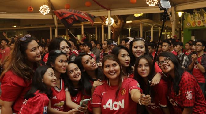 Para fans wanita melakukan selfie saat mendukung MU melawan City. (Bola.com/Vitalis Yogi Trisna)