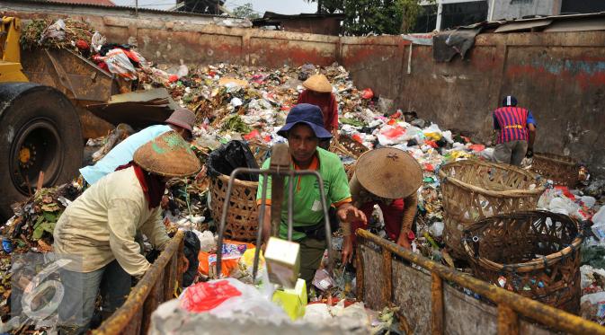 Petugas sampah memilah milih sampah di kawasan Pasar Minggu, Jakarta, Senin (26/10). Pemerintah Provinsi DKI Jakarta berencana membangun empat fasilitas pengolahan sampah tahun depan. (Liputan6.com/Gempur M Surya)