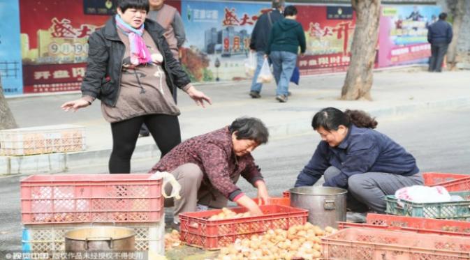 Warga membantu pengemudi mengumpulkan telur yang masih utuh. (Shanghaiist)