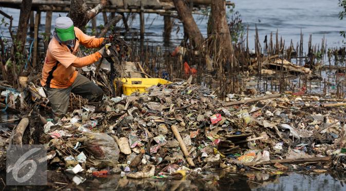 Petugas Dinas Kebersihan DKI Jakarta membersihkan sampah di pesisir Muara Angke, Jakarta, Kamis (29/10). (Liputan6.com/Faizal Fanani)