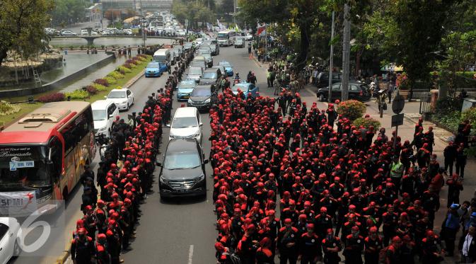 Ribuan buruh berjalan menuju bundaran Istana Merdeka, Jakarta, Jumat (30/10/2015). Aksi tersebut menimbulkan kemacetan lalu lintas kendaraan di sekitar kawasan Istana Negara. (Liputan6.com/Gempur M Surya)