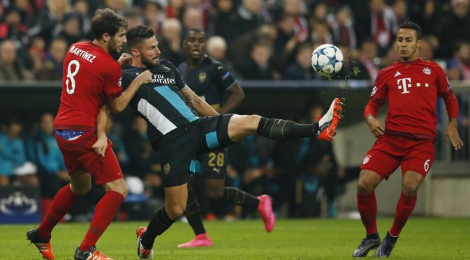 Olivier Giroud mencoba mempertahankan bola dari Javi Martinez