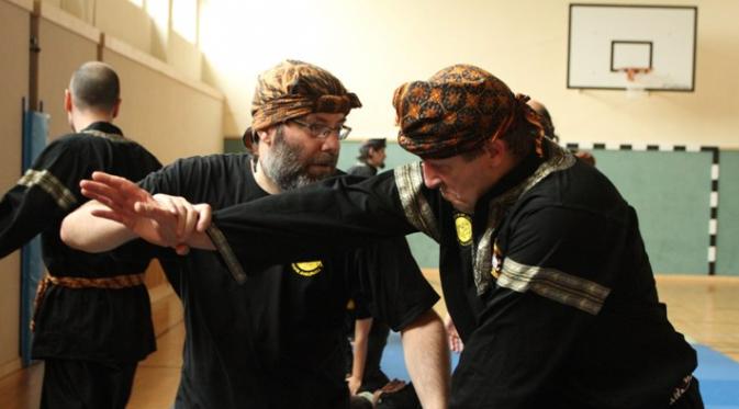 Stefan Taibl (kanan) mengajari tekni silat kepada salah satu murid Anak Harimau yang sudah lanjut usia. (bola.com/Reza Khomaini)