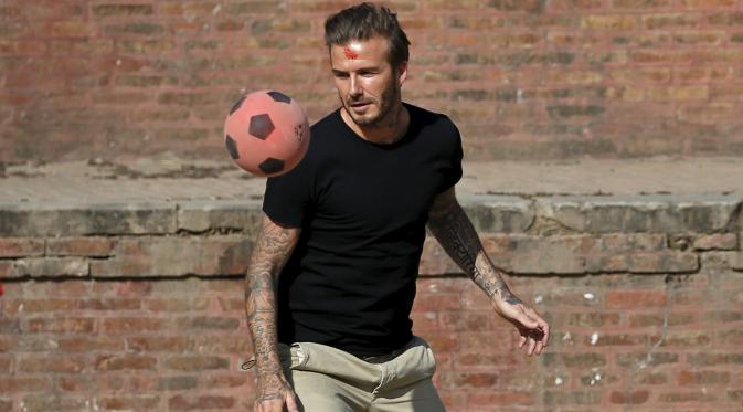 David Beckham mengoper bola ketika melakukan pertandingan amal untuk mengumpulkan dana bagi UNICEF di kota tua Bhaktapur, Nepal, Jumat (6/11). (REUTERS / Navesh Chitrakar)