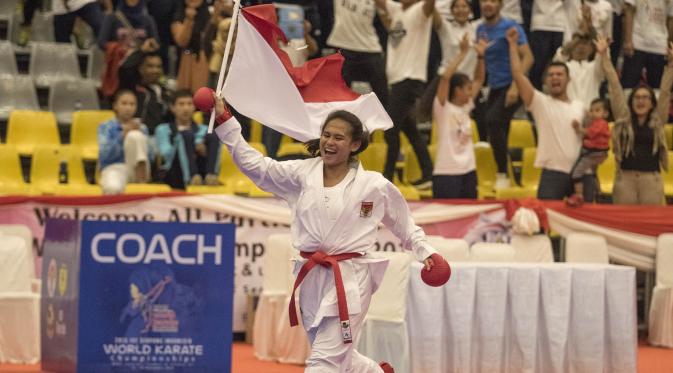 Karateka Indonesia, Ceyco Georgia Zefanya mengibarkan merah putih usai meraih emas pada Kejuaraan Dunia Karate Junior, Cadet dan U-21 di ICE BSD, Tangerang, Jumat (13/11/2015). (Bola.com/Vitalis Yogi Trisna) 