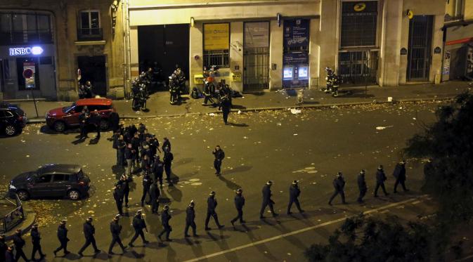 Polisi berjaga-jaga di sekitar area tempat terjadinya penembakan dan bom bunuh diri yang dilakukan teroris di Paris, Perancis, Jumat (13/11/2015). Dikabarkan ada 140 orang tewas dalam aksi teroris tersebut. (Reuters)