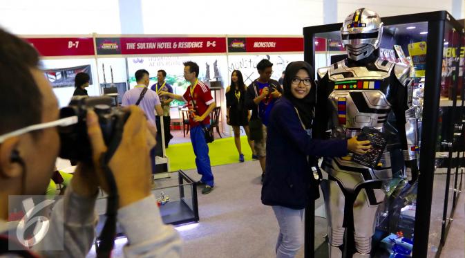 Pengunjung berfoto tokoh film super hero Gaban saat pameran Indonesia Comic Con di JCC, Jakarta, Sabtu (14/11). Pameran mainan dan comic ini berlangsung dari tanggal 14-15 November 2015. (Liputan6.com/Fery Pradolo)