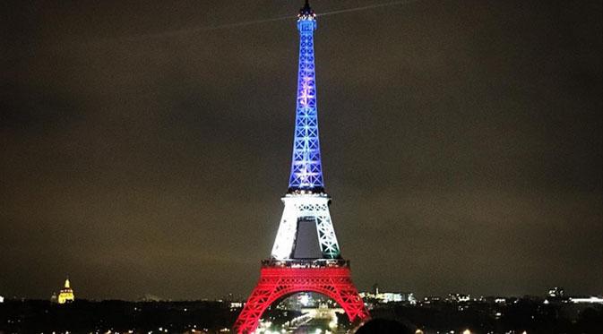 Menara Eiffel menyalakan bendera Prancis usai aksi teror di Paris. (CNN)