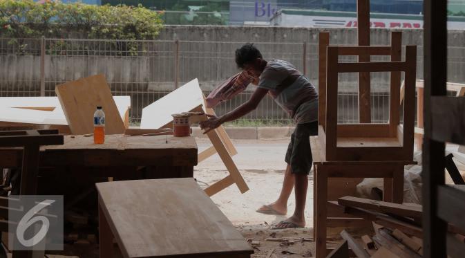 Pekerja tengah menyelesaikan pembuatan kursi dan meja di Jakarta, Jumat (20/11). Data Kementerian Koperasi dan UKM ketiga bank berupaya untuk mendorong penyaluran KUR kisaran Rp24-25 triliun hingga akhir tahun 2015.  (Liputan6.com/Angga Yuniar)