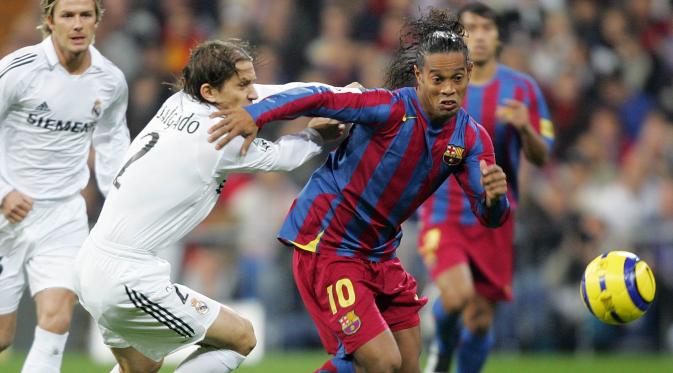 Ronaldinho mengelabui Michel Salgado dalam laga El Clasico di Stadion Santiago Bernabeu, Madrid, (19/11/2005). Ronaldinho mencetak dua dari tiga gol kemenangan Barcelona. (AFP Photo/Javier Soriano)