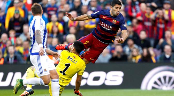 Luis Suarez berduel dengan kiper Real Sociedad, Geronimo Rulli, dalam lanjutan La Liga Spanyol di Stadion Camp Nou, Barcelona, Sabtu (28/11/2015). (EPA/Alejandro Garcia)