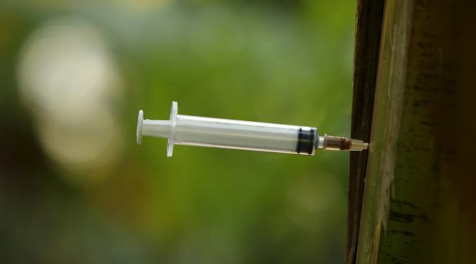 Jarum suntik heroin bekas para pecandu narkoba tertancap pada pohon pisang di Hanoi ,Vietnam, Selasa (1/12). Sejak 2005  remaja di Asia Pasifik meninggal karena AIDS meningkat dua kali lipat.  (REUTERS/Kham)