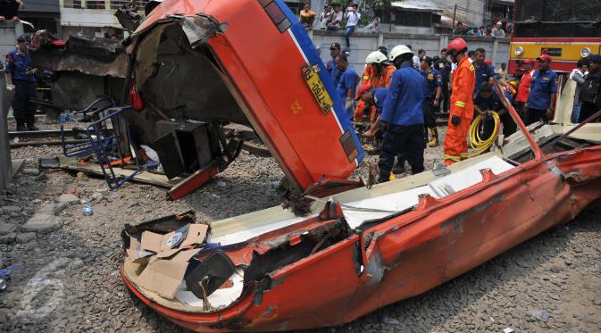 Kecelakaan hebat terjadi antara sebuah Metro Mini dengan kereta Commuter Line di perlintasan Angke, Tambora, Jakarta, Minggu (6/12/2015). Bus hancur dan terseret hingga 200 meter. Sebanyak 13 orang dilaporkan tewas. (Liputan6.com/Gempur M Surya)  