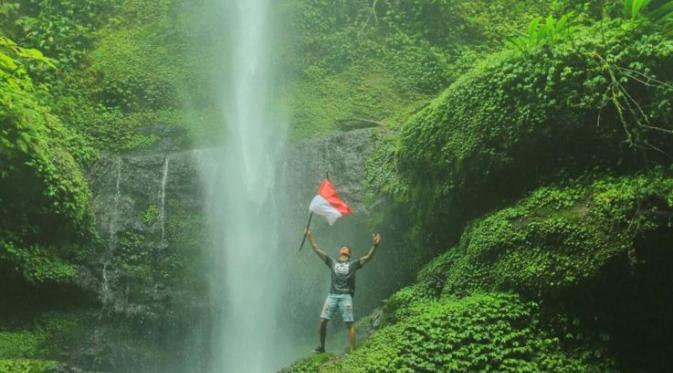 Marshall Sastra tetap mengibarkan sang merah putih diantara deru air terjun. (Instagram @marshallsastra)