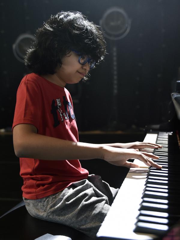 Pianis belia asal Indonesia, Joey Alexander saat latihan bermain piano di Prancis, 10 Agustus 2015. Pianis jazz berusia 12 tahun itu menjadi musisi pertama asal Tanah Air yang masuk nominasi ajang Grammy Awards 2016.  (AFP PHOTO/PASCAL Pavani)