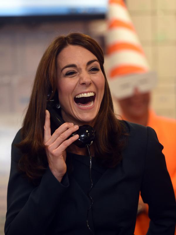 Duchess of Cambridge, Kate Middleton tertawa lepas sambil menggenggam gagang telepon saat menjadi broker dalam acara amal tahunan ICAP di London, Inggris, Rabu (9/12/2015). (AFP PHOTO/POOL/JEREMY Selwyn)