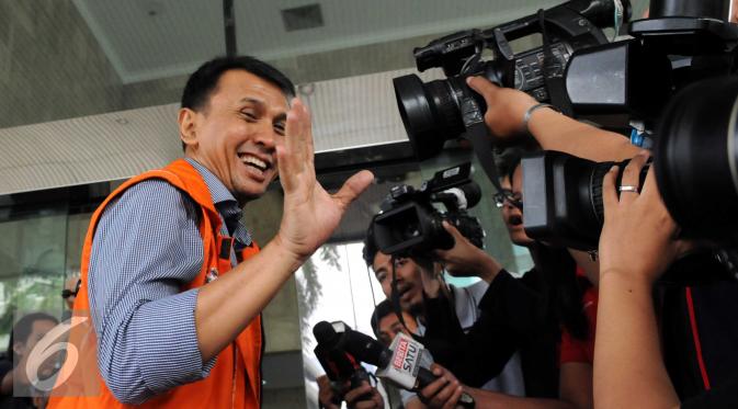 Gatot Pujo Nugroho menyapa wartawan usai keluar dari mobil tahanan, Jakarta, Jumat (11/12). Pemandangan menarik dan lucu ketika Gatot tak sadar mengenakan rompi tahanan KPK yang ternyata terbalik. (Liputan6.com/Helmi Afandi)