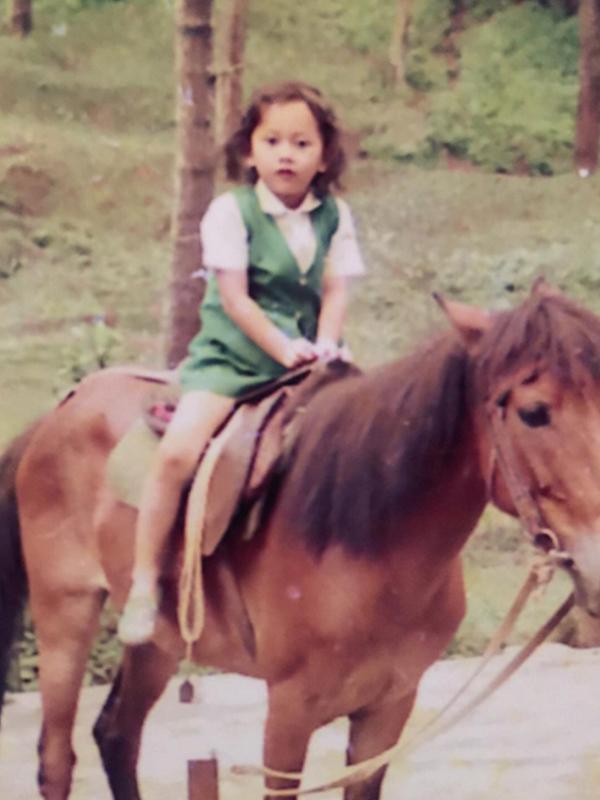 Aura Kasih meamosting foto masa kecil saat menunggang kuda di Instagram.