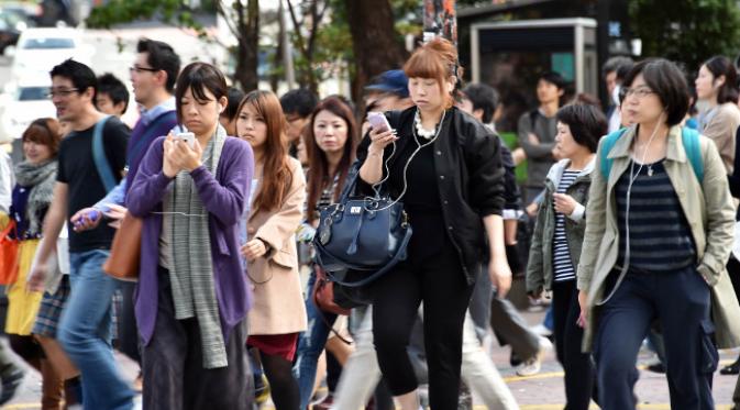 Penduduk Jepang menyebrang jalan sambil ramai-ramai melihat ponsel. (foto: japantimes.com)