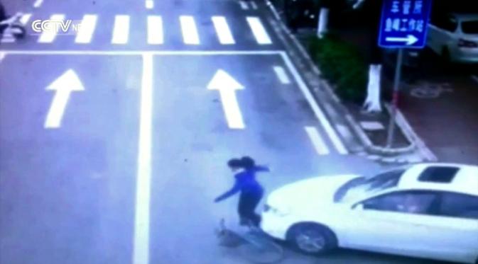 Warga kota gotong royong mengangkat mobil demi menyelematkan pesepeda ini. (Sumber 9news.com.au)