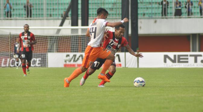 Penyerang sayap Persipura Jayapura, Ferinando Pahabol berduel dengan pemain sayap Pusamania Borneo FC, Arpani dalam lanjutan babak 8 besar Grup E Piala Jenderal Sudirman di Stadion Maguwoharjo, Sleman, Sabtu (19/12/2015). (Bola.com/Romi Syahputra) 