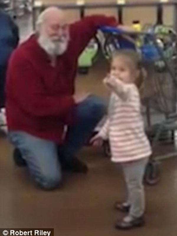Gadis kecil berbincang dengan laki-laki yang disangkanya sebagai Santa Claus. | via: Robert Riley