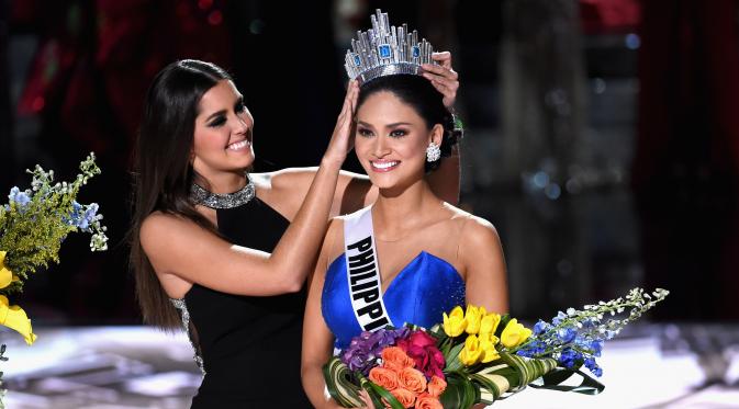 Miss Universe 2014, Paulina Vega saat menyematkan mahkota ke Miss Filipina, Pia Alonzo Wurtzbach usai dinobatkan sebagai pemenang Miss Universe 2015 di The AXIS Las Vegas, AS, Minggu (20/12). (Ethan Miller/Getty Images/AFP)