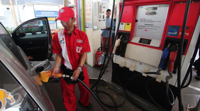  Petugas mengisi bahan bakar jenis Premium di SPBU Cikini, Jakarta, Kamis (24/12). Jelang awal tahun 2016, Pemerintah memutuskan menurunkan harga Bahan Bakar Minyak (BBM) jenis Premium dan Solar. (Liputan6.com/Angga Yuniar)