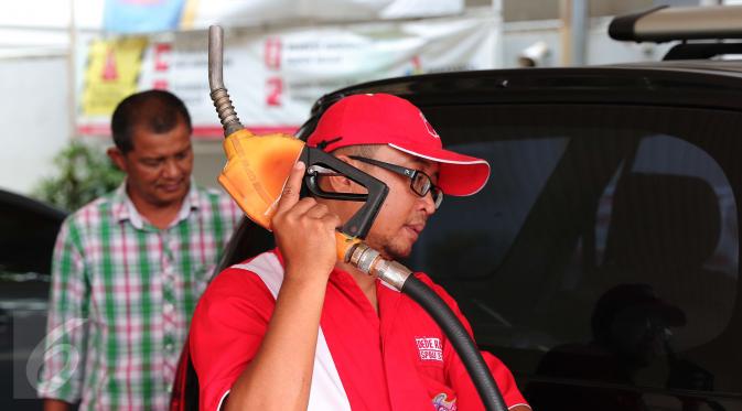 Petugas mengisi bahan bakar jenis Premium di SPBU Cikini, Jakarta, Kamis (24/12). Untuk bahan bakar jenis Premium turun Rp 150/liter dan harga solar turun sebesar Rp 800/liter. (Liputan6.com/Angga Yuniar)