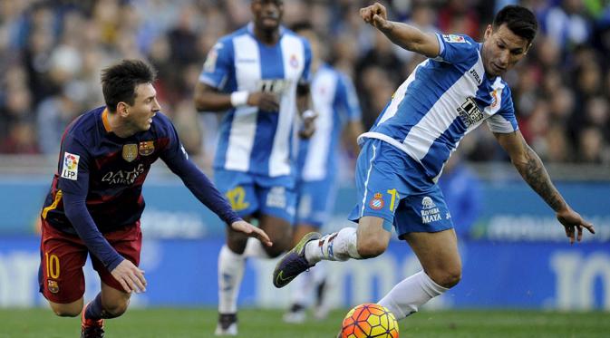 Pemain Barcelona, Lionel Messi, terjatuh saat berebut bola dengan pemain Espanyol, Hernan Perez, pada laga La Liga Spanyol. Trio Messi, Neymar dan Suarez gagal cetak gol, Barca hanya mampu bermain imbang. (Reuters/Stringer)