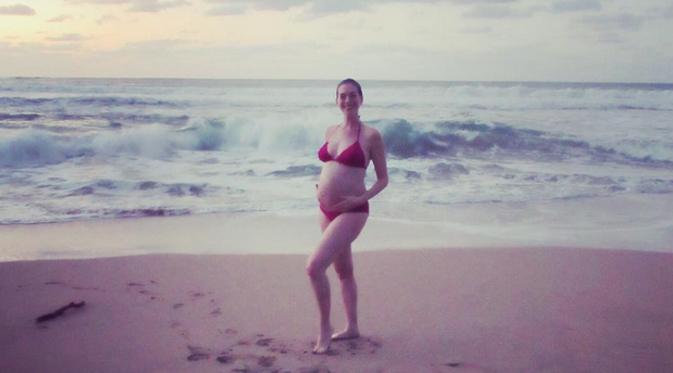 Anne Hathaway pamer perut buncit saat pakai bikini. (foto: instagram.com/annehathaway)