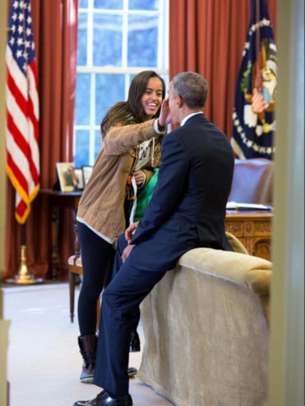 23 Februari 2015. Anak tertua Presiden Obama, Malia menyeka sesuatu dari wajah ayahnya. (Via: dailymail.co.uk)