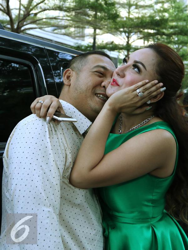 Regina dan suaminya, Krisna Murti berpose usai menggelar konferensi pers, Jakarta, Kamis (7/1/2015). Regina mengaku mendapat mahar 1 M dari suami ketiganya tersebut. (Liputan6.com/Herman Zakharia)
