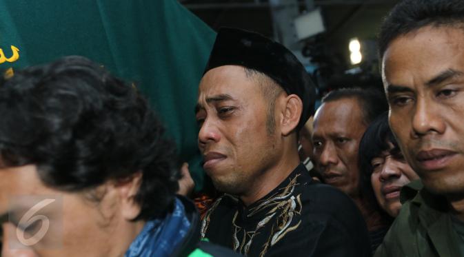 Salah seorang sahabat Budi Anduk terlihat menangis saat membawa keranda Jenazah Budi Anduk, Bekasi, Senin (11/1/2016). Budi Anduk menghembuskan nafas terakhir pada usia 47 tahun di RS Dharmais, Jakarta. (Liputan6.com/Herman Zakharia)